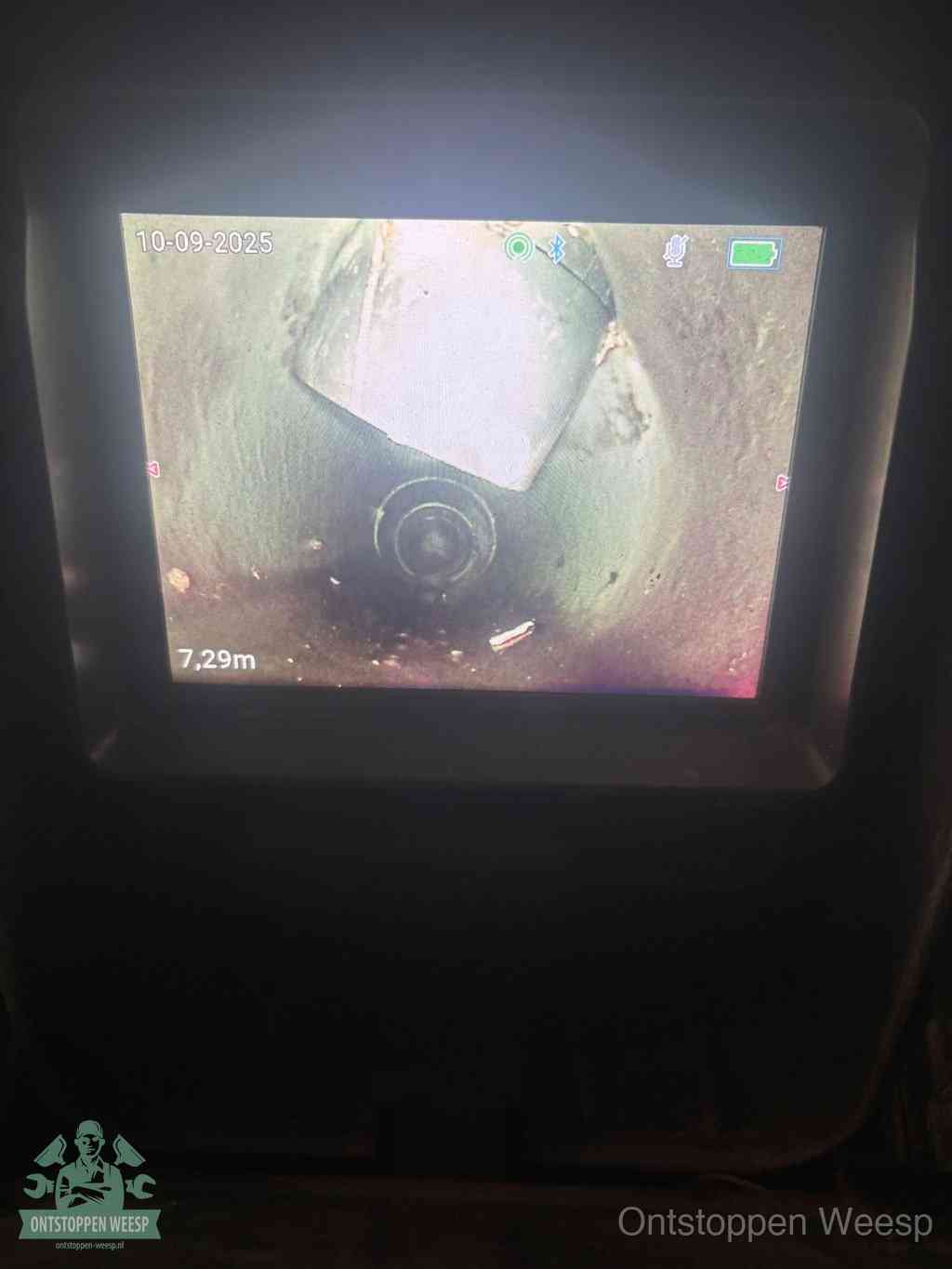 Het scherm van een rioolinspectiecamera toont de binnenkant van de leiding, eerst vaststellen waar de verstopping zit in Weesp
